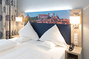 Doppelbett mit Panorama von Nürnberg auf Leinwand an der Wand