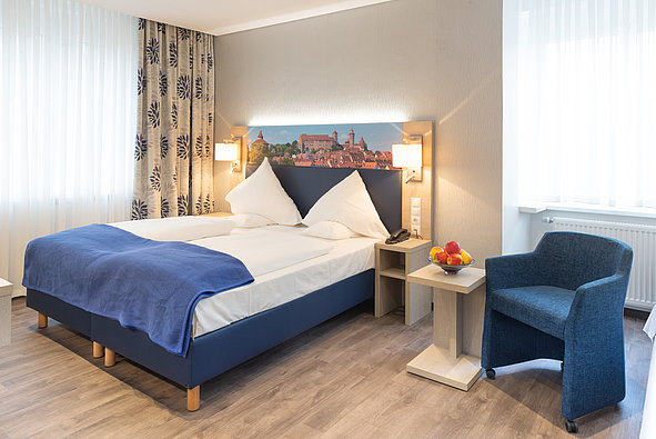 Zimmer mit Doppelbett und das Panorama von Nürnberg als Bild an der Wand